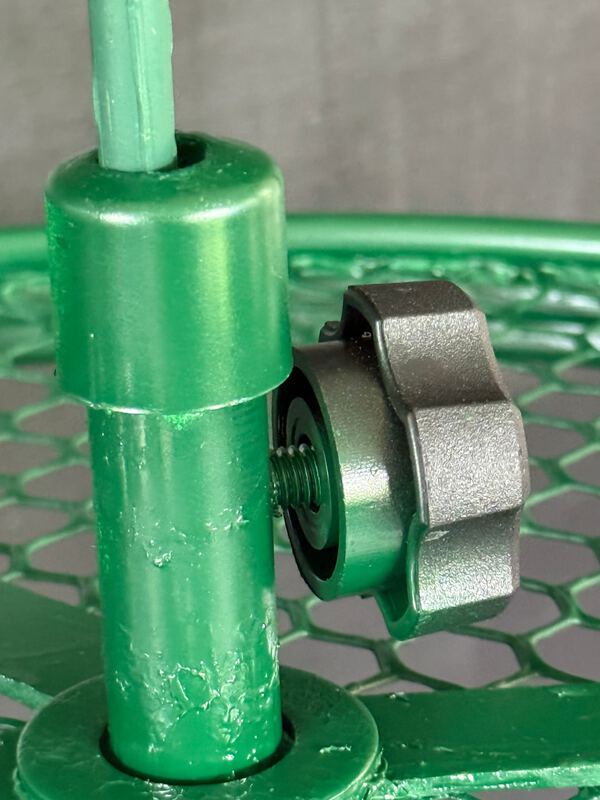 Close-up of the hub collar around the green plant stake, with a black oversized hand screw threaded into its side